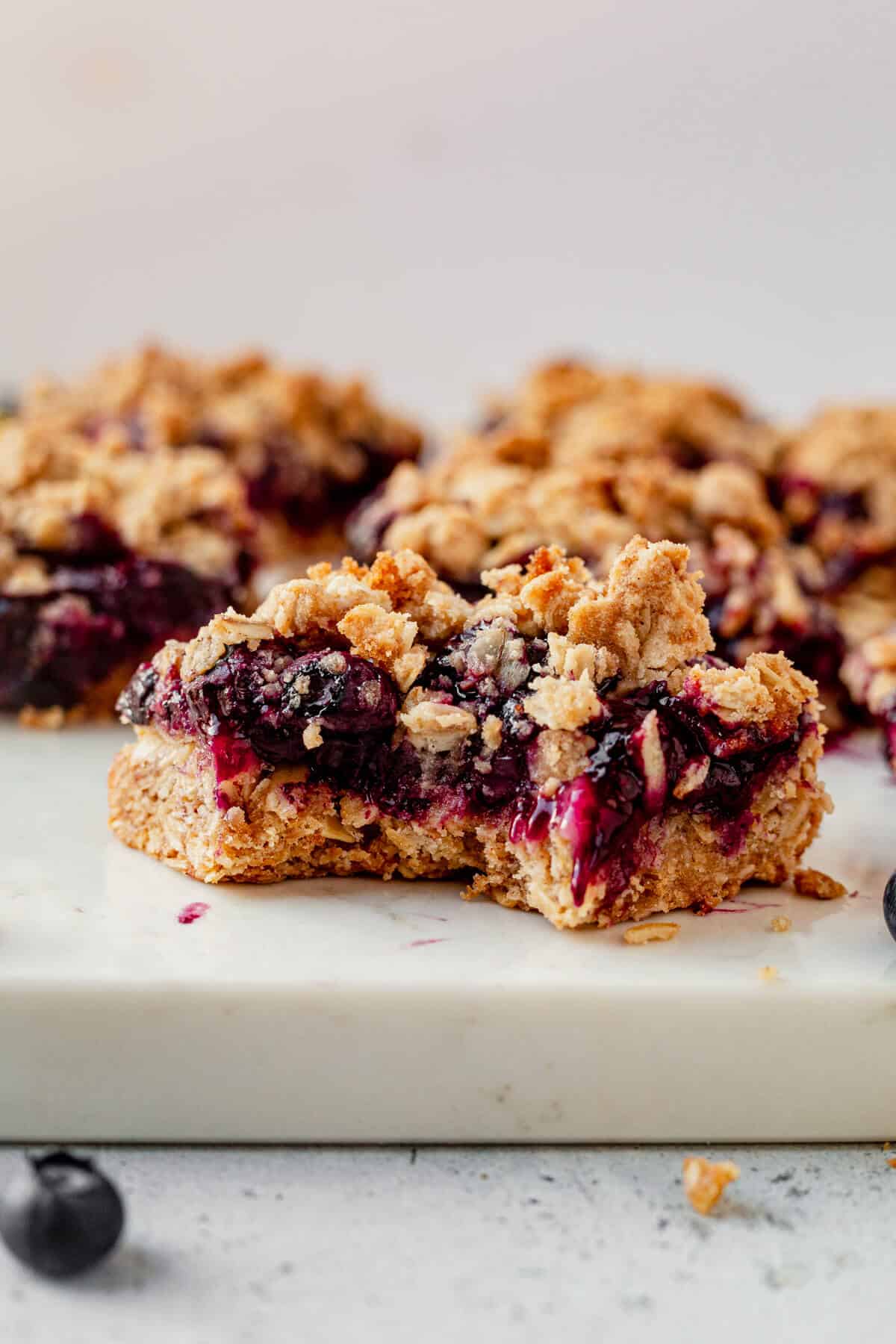 a bite taken out of a blueberry crumb bar on the counter