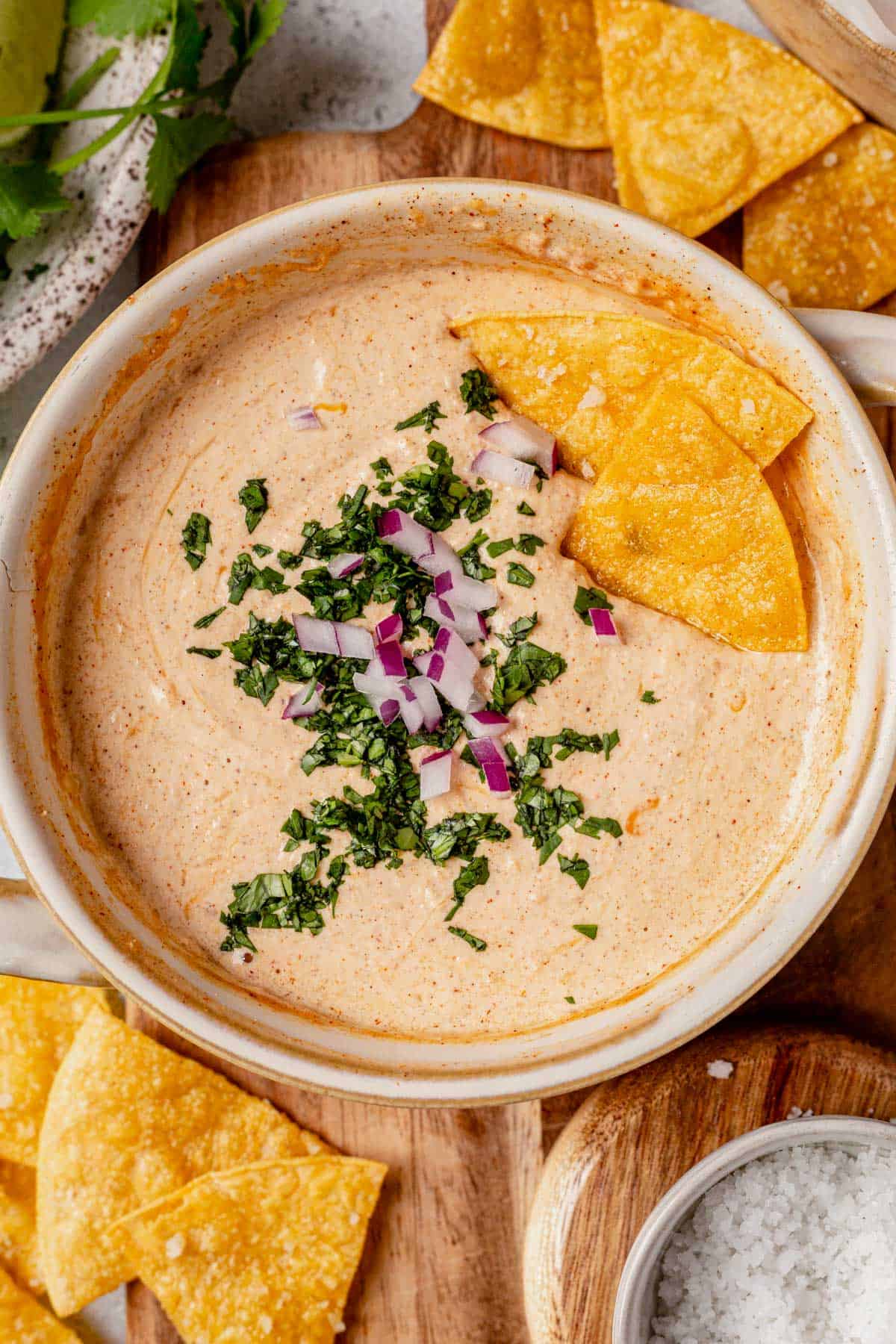queso in a bowl topped with cilantro and red onion
