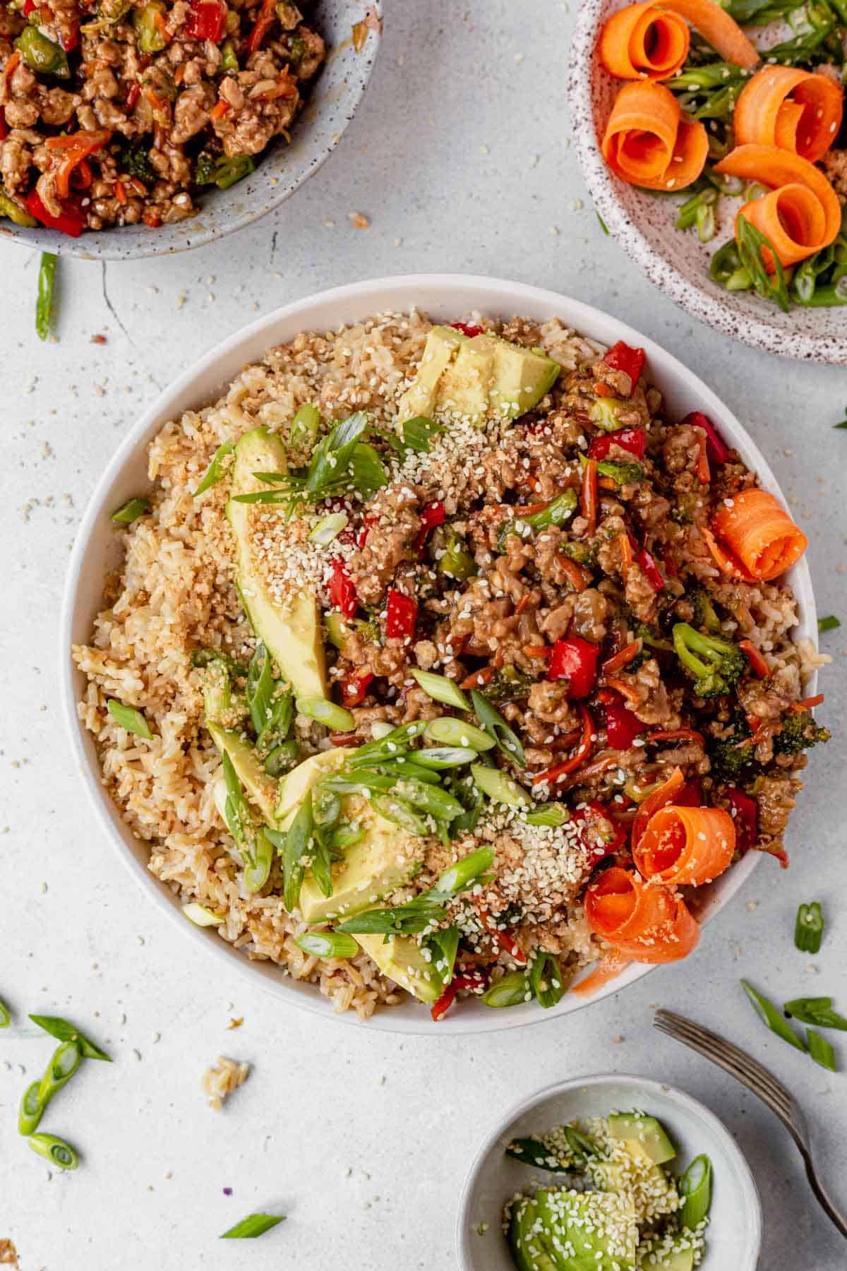 teriyaki turkey bowl with avocado and sesame seeds on top.